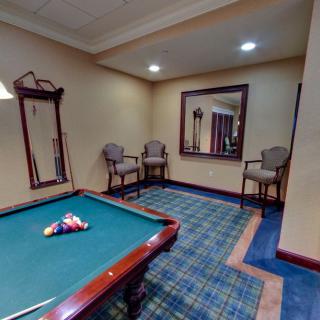 A cozy game room featuring a pool table and seating area.