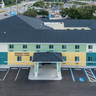 Aerial view of a hotel with a parking lot in front.