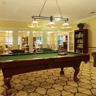 A cozy game room featuring a pool table and warm lighting.