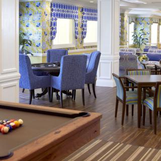 A cozy lounge with a billiards table and dining area, featuring vibrant decor.