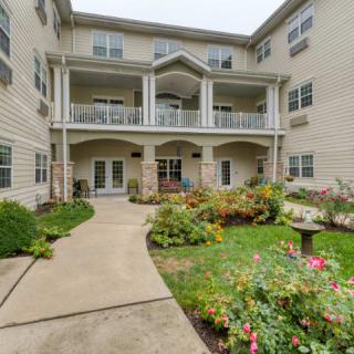 A residential building with a landscaped garden in the foreground.