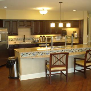 A modern kitchen with wooden cabinets and a central island featuring bar stools.