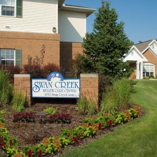 Entrance sign of a nursing care center with well-maintained landscaping.