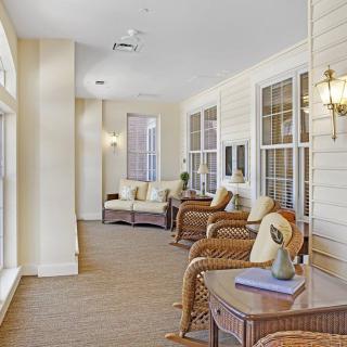 A bright and cozy indoor seating area with wicker furniture and decorative pillows.