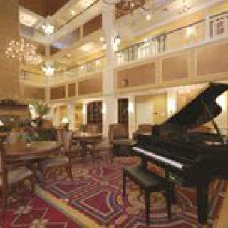 Elegant hotel lobby with a grand piano and luxurious decor.