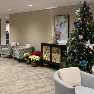 A festive lobby area decorated for the holidays, featuring a Christmas tree and comfortable seating.