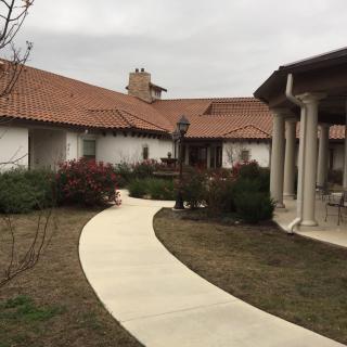 A view of a house with a winding pathway through the garden.