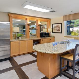 A modern kitchen with wooden cabinets and a granite countertop dining area.