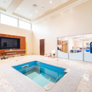 A spacious indoor pool area designed for relaxation and luxury, featuring modern aesthetics and ample natural light.