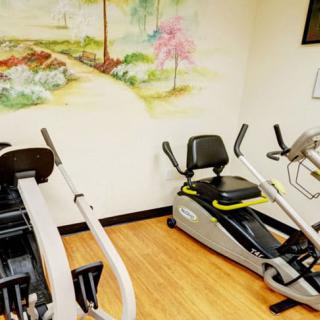 A small indoor gym area with exercise equipment including stationary bikes and a rowing machine.