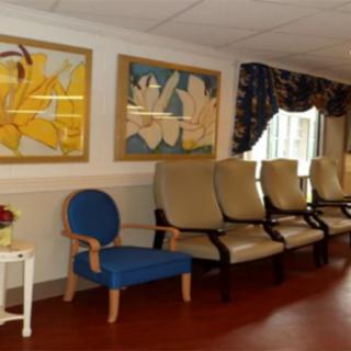 A waiting room with several chairs and colorful artwork on the walls.
