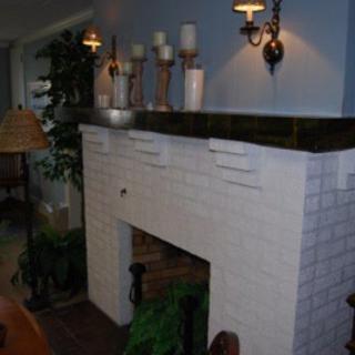 A cozy interior with a decorated fireplace mantel featuring candles and plants.