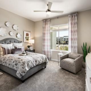 A beautifully designed modern bedroom with a cozy atmosphere, featuring elegant textiles and natural light.