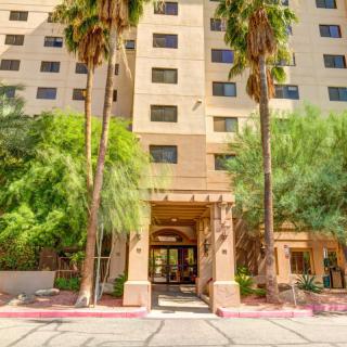 The entrance to a residential apartment building surrounded by palm trees.