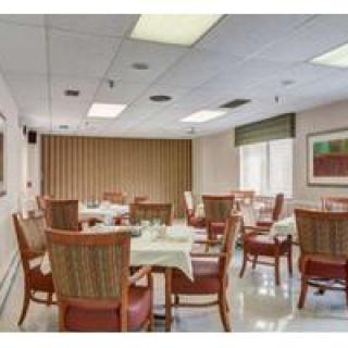 An empty dining room with neatly arranged tables and chairs, set up for service.
