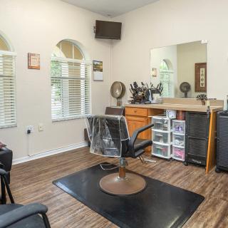 A clean and organized hair salon interior with a styling station and chair.