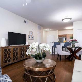 A modern living room with elegant decor and an open view into the kitchen.