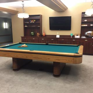 A well-furnished billiards room featuring a pool table and wall-mounted TV.