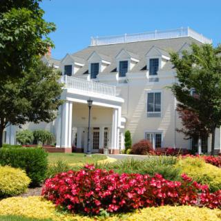 A beautiful building surrounded by a colorful garden in summer.