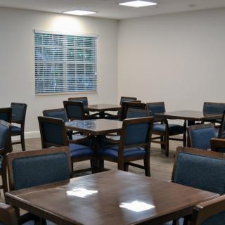 An empty dining area with multiple tables and chairs arranged neatly.
