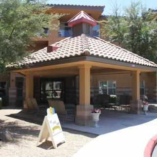 An outdoor view of a building entrance with a covered porch and tiled roof.