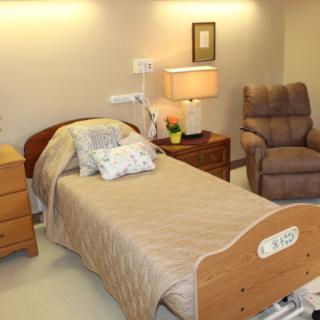 A cozy hospital room with a single bed and recliner chair.