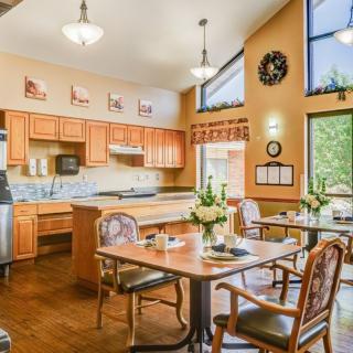 A well-lit kitchen and dining area with wooden cabinets and furniture.