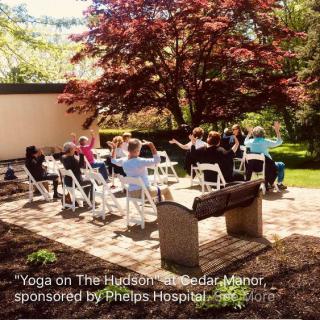 A group participates in a yoga session outdoors at Lyndhurst Manor.