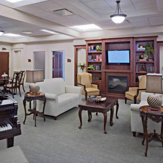 A cozy living room with comfortable seating, a bookshelf, and a television.