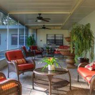 A cozy sunroom with comfortable seating and indoor plants, filled with natural light.