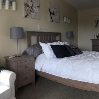 A stylish bedroom with a neatly made bed, nightstands, and elegant decor.
