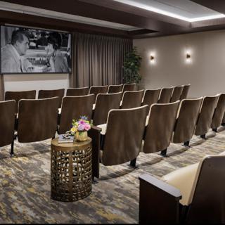 A small, intimate theater with comfortable seating and a large movie screen.