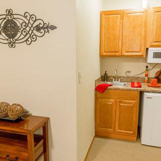 A compact kitchen with wooden cabinets and appliances.