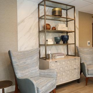 A modern interior setup featuring stylish chairs and an open shelving unit adorned with decorative items.