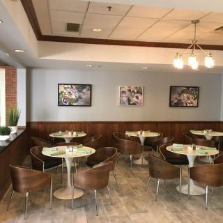 A modern cafe interior with round tables and comfortable chairs.