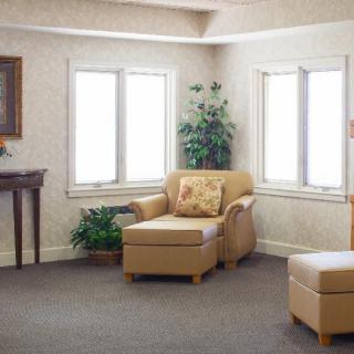 A cozy living room with a comfortable armchair and decorative plants by the window.