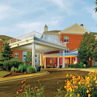A modern building with a landscaped entrance and vibrant flowers.