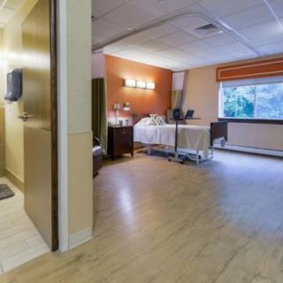A clean and well-lit hospital room with a patient bed and medical equipment.