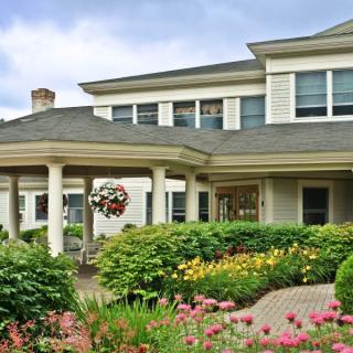 A charming house with a beautifully landscaped garden and porch.