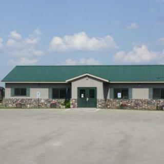 A commercial building with a green roof and stone facade.
