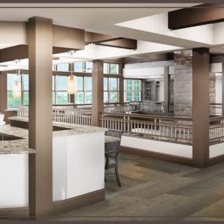 A spacious and modern restaurant interior with large windows and comfortable seating.