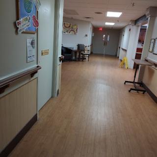 A quiet corridor in a healthcare facility, showcasing clean lines and minimal furniture.