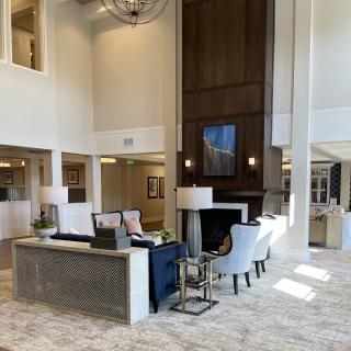 A spacious and elegantly designed lobby featuring modern furniture and a high ceiling.