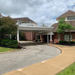 A welcoming entrance to a well-designed building, surrounded by neatly landscaped greenery.