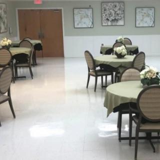 An empty dining room with round tables and chairs neatly arranged, ready for use.