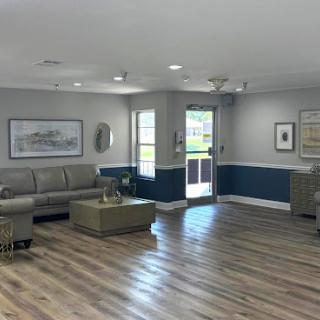A bright and spacious living room featuring modern furniture and a stylish blue accent wall.
