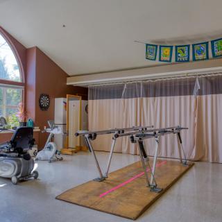 A therapy and exercise room with specialized equipment for rehabilitation exercises.