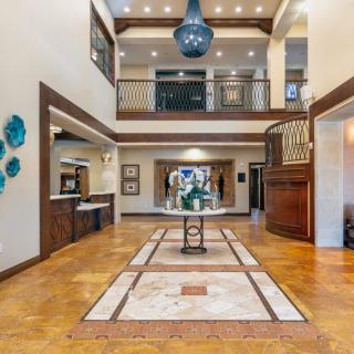 A spacious and modern lobby with elegant architectural details and a large chandelier.