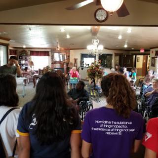 A community gathering taking place indoors, where people are engaged in conversation and activities.