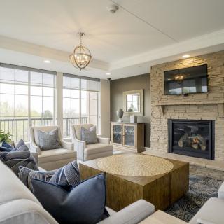A modern living room with a large window, fireplace, and stylish furniture.